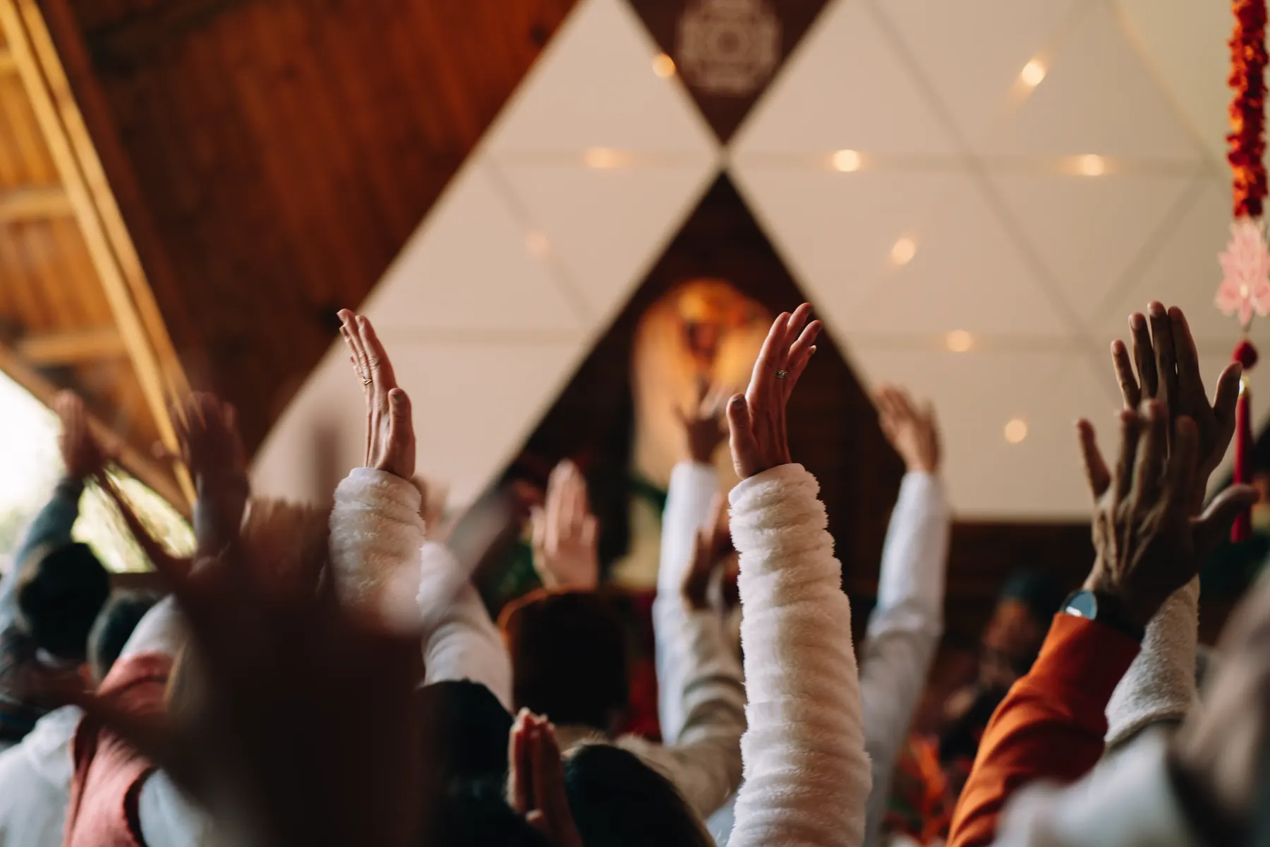 Manos en alto entre las personas durante una ceremonia en el templo