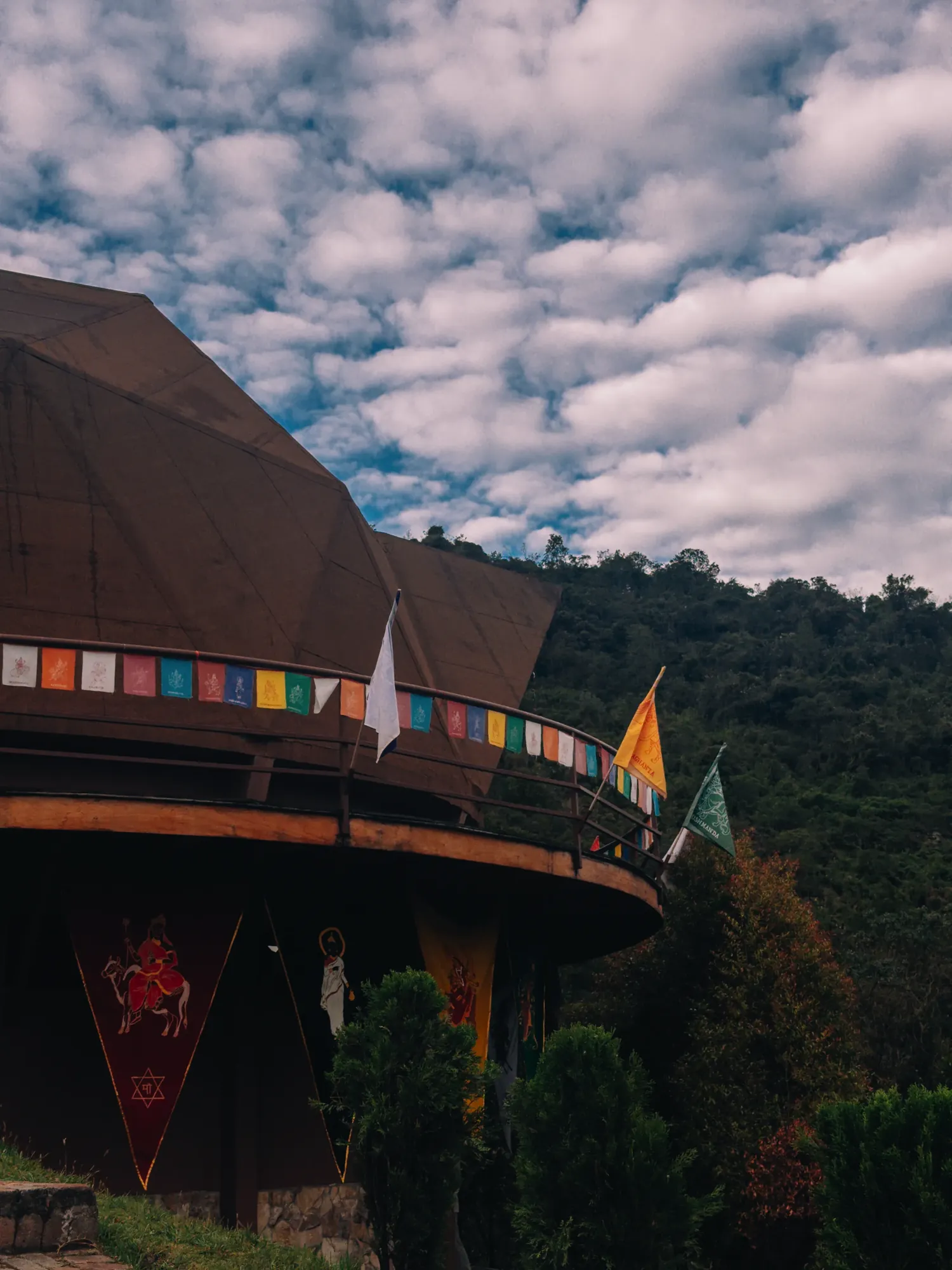 Cúpula del templo vista desde fuera, con banderas de oración y un cielo de nubes