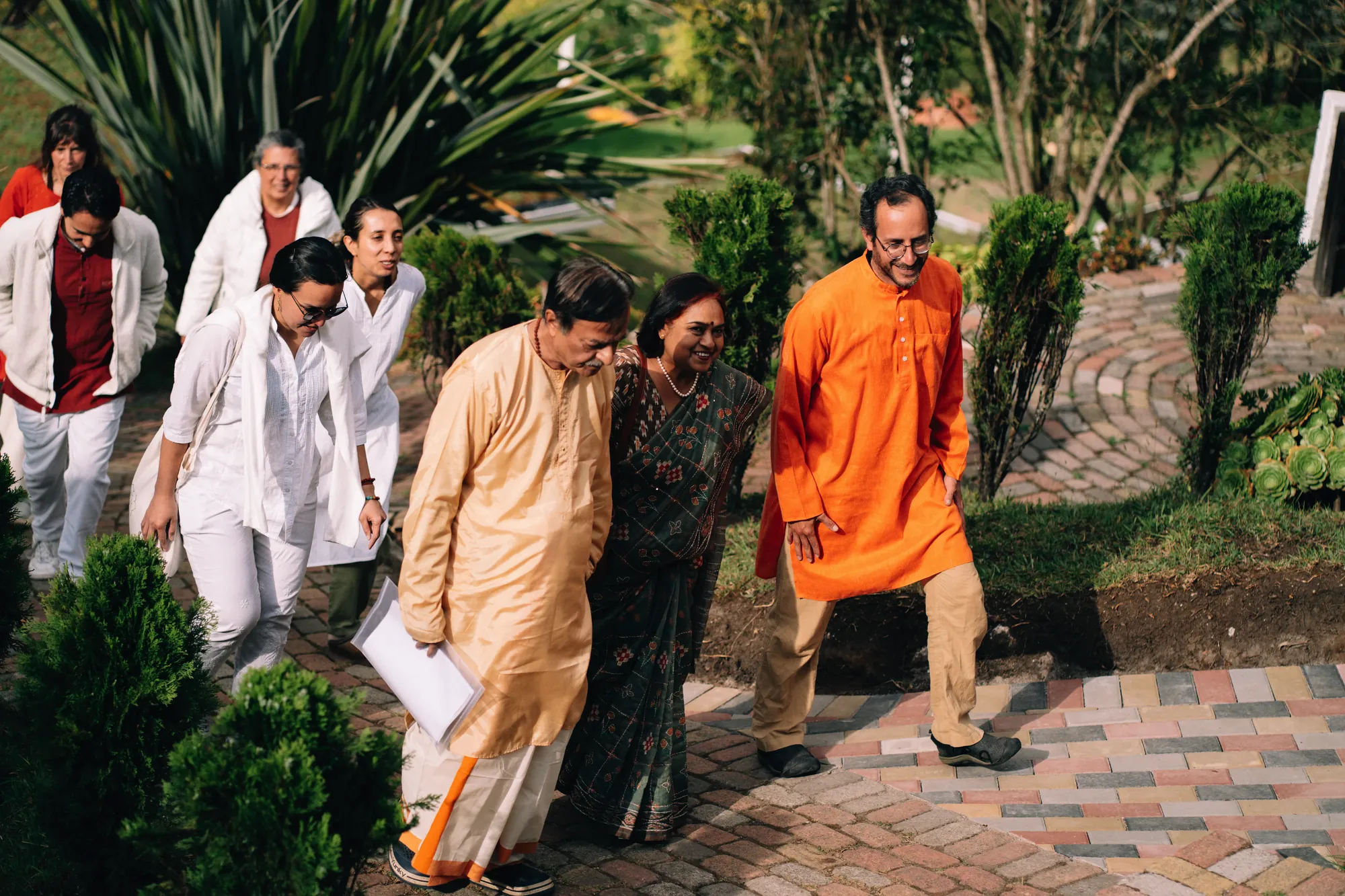 Un grupo camina por el sendero de adoquines del ashram hacia el templo