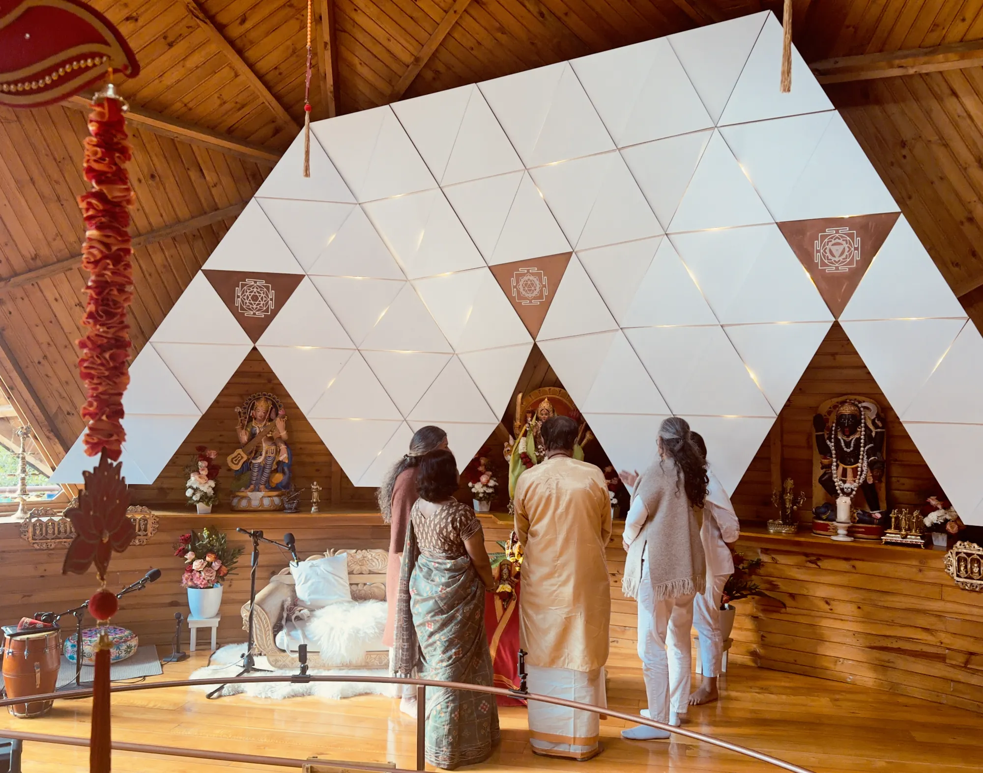 Visitantes y anfitriones de pie frente al altar de las Devis, en el templo